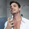 Homem aplicando perfume no pescoço