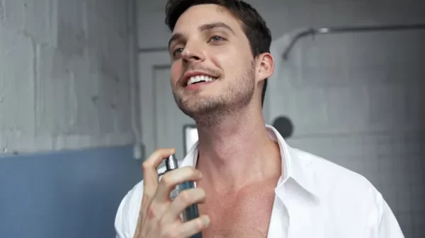 Homem aplicando perfume no pescoço