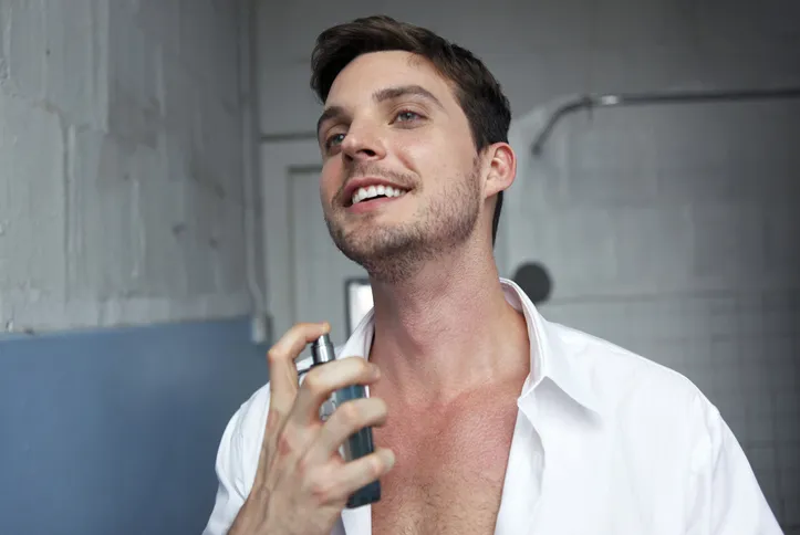 Homem aplicando perfume no pescoço