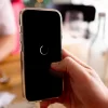 Celular travando na mão de um usuário com tela congelada