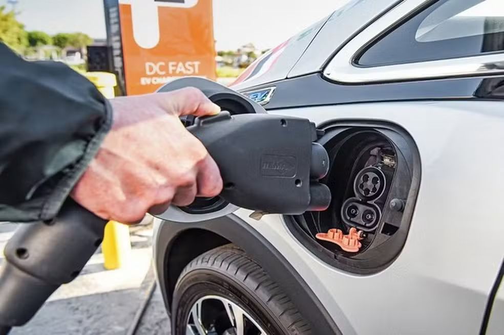 carro elétrico sendo recarregado em ponto urbano