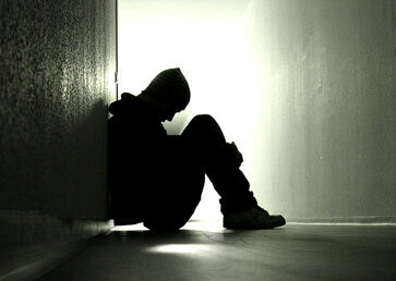 Pessoa chorando sozinha, afastada de todos