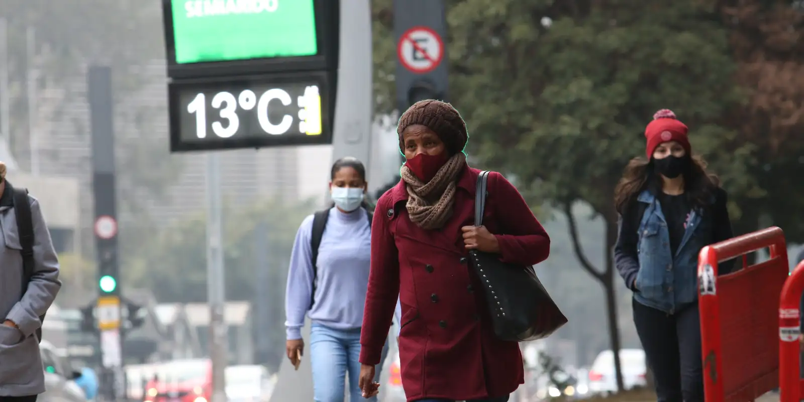 mulher com blusa de frio registrando 13 graus
