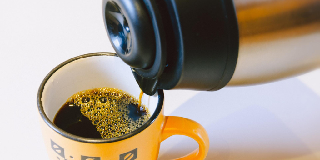 Garrafa de café servindo em uma xícara