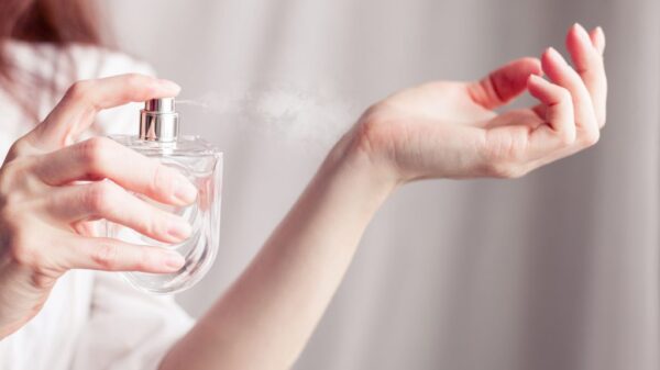 Mulher passando perfume no pulso